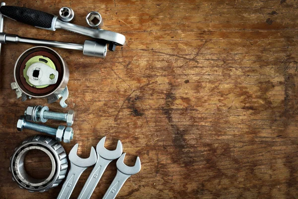 tools and old auto parts on wooden background