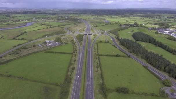 Vidéo 4k aérienne d'une autoroute irlandaise très fréquentée avec survol du pont et des ronds-points . — Video