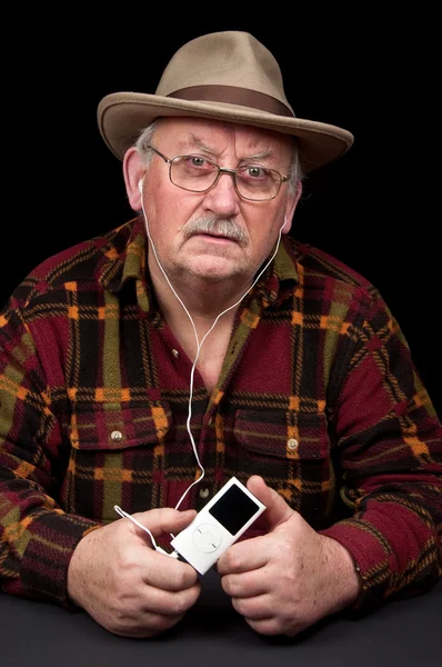 Senior male listening to mp3 music player — Stock Photo, Image