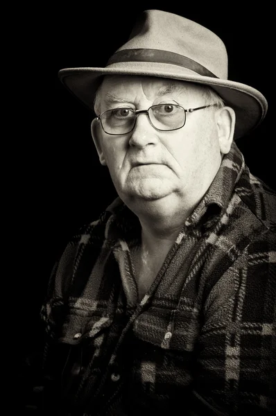 Пенсионер в очках и шляпе — стоковое фото