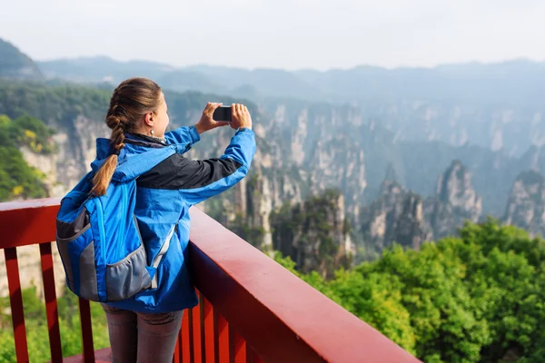 Young female tourist taking photo of Zhangjiajie mountains — Stockfoto