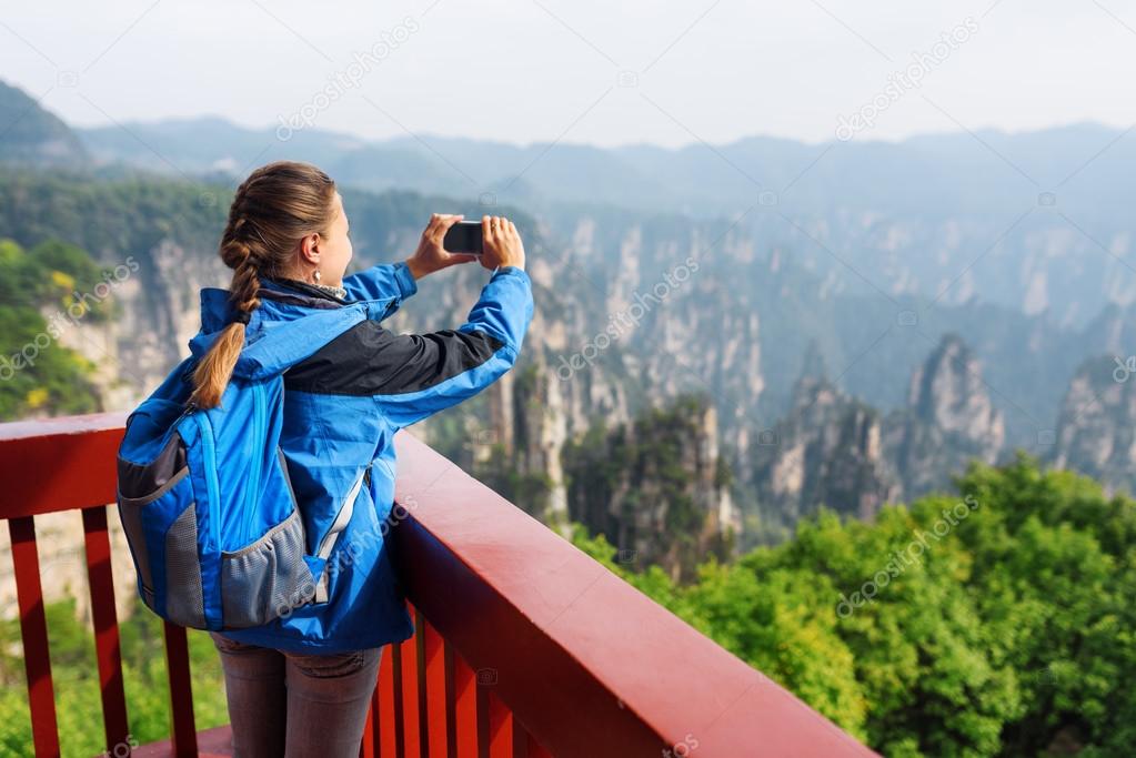 Young female tourist taking photo of Zhangjiajie mountains
