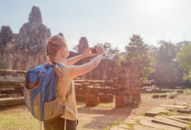 Kadın turist Angkor Thom ile smartphone Bayon Tapınağı,