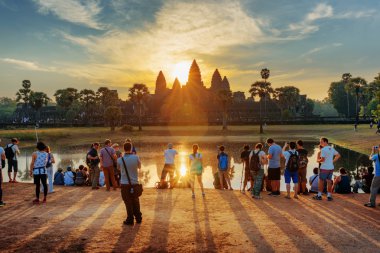 Çok sayıda turistin güneş doğarken Angkor Wat resim çekmek