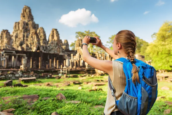 Młody turysta kobiece biorąc obraz świątyni Bayon w Angkor — Zdjęcie stockowe