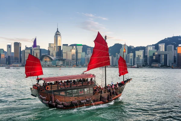 Turister på segelfartyget med röda segel korsar Victoria Harbour — Stockfoto