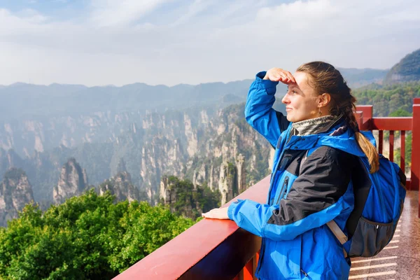 Junge lächelnde Touristin genießt atemberaubende Aussicht auf die Berge — Stockfoto