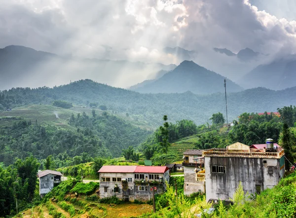 Old houses at highlands and rays of sunlight through clouds — Stock Photo, Image