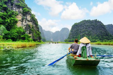 Tekne turist. Kürekçi kürek itmek için ayaklarını kullanarak. Vietnam