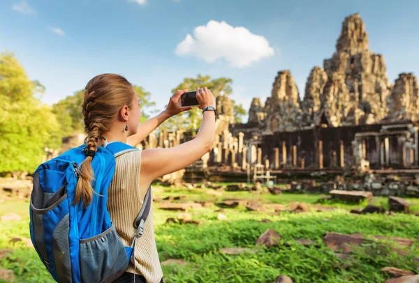 Young female tourist taking picture of Bayon temple, Angkor — Stock Fotó