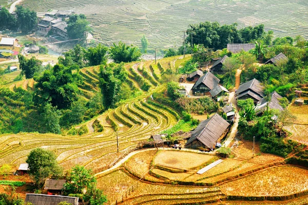 Terraços de arroz cheios de água e telhados de casas de aldeia — Fotografia de Stock