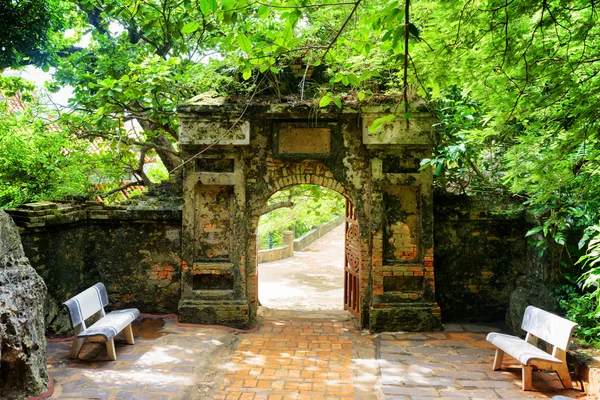 Antigua puerta de piedra que conduce al enigmático jardín tropical —  Fotos de Stock
