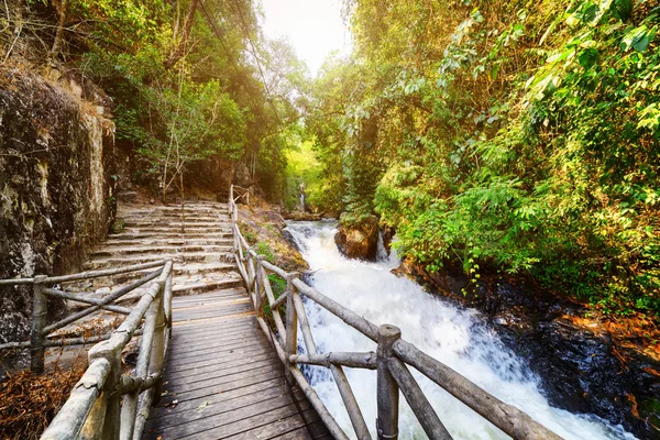 Wooden boardwalk and stone stairs leading along mountain river — Stock Photo, Image