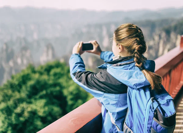Turista femenina tomando fotos de montañas. Imagen tonificada — Foto de Stock