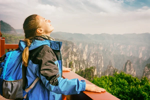 Gülümseyen kadın turist güneş ışığı ve manzaranın tadını çıkarıyor. Tonlu görüntü — Stok fotoğraf