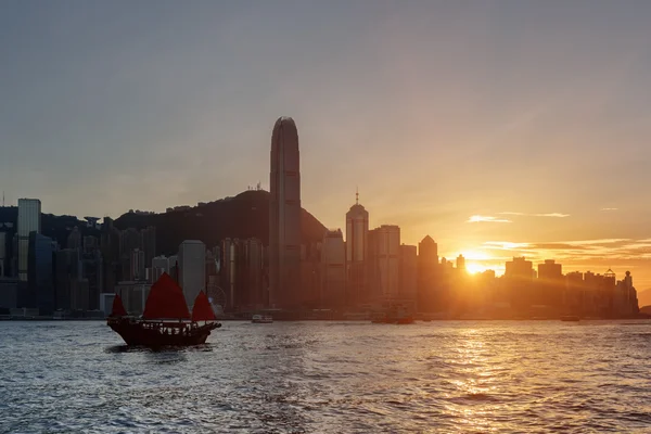 Hong Kong Island skyline a naplemente. A Victoria kikötőre vitorlás hajó — Stock Fotó