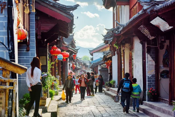 Locals in een schilderachtige straat in de oude stad van Lijiang, China — Stockfoto