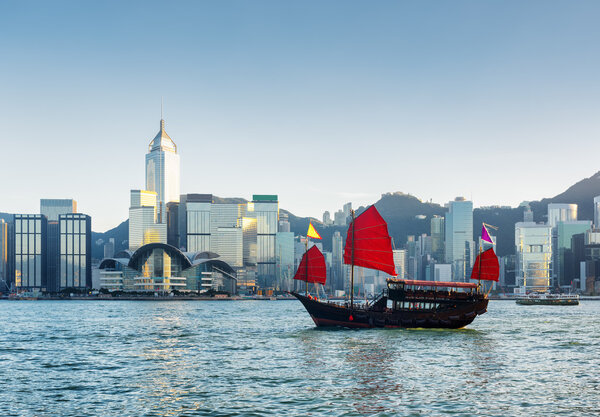 Traditional Chinese sailing ship in Victoria harbor at evening