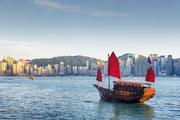 Wooden sailing ship and the Hong Kong Island skyline at evening