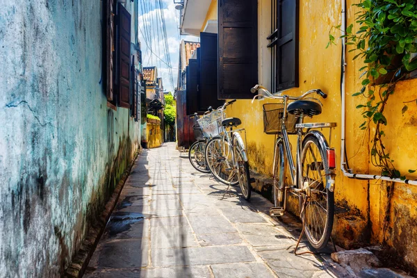 Bicicletas estacionadas perto da parede amarela, Hoi An Ancient Town — Fotografia de Stock
