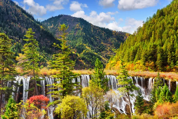 De NUO RI lang-waterval (Nuorilang) tussen beboste bergen — Stockfoto