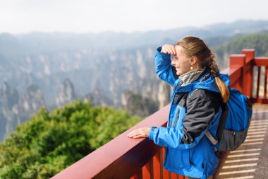 Genç gülümseyen kadın turist inanılmaz dağ manzarayı