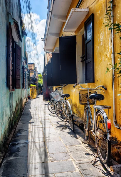 Jízdní kola zaparkované žluté zdi, Hoi (Hoian), Vietnam — Stock fotografie