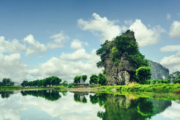 Beautiful natural karst tower reflected in water. Toned image — Stock Photo, Image