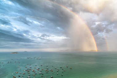 Güney Çin Denizi 'nin Nha Trang Körfezi üzerinde muhteşem bir çift gökkuşağı. Körfezdeki geleneksel Vietnam balıkçı teknelerinin inanılmaz hava manzarası..