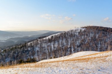 Muhteşem kış manzarası. Karla kaplı ağaçlık dağların muhteşem manzarası, Sibirya. Yenisey Nehri arka planda görünür. Sibirya Kış Ormanı.