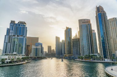 Dubai, Birleşik Arap Emirlikleri - 2 Kasım 2018: Gün batımında Dubai Marina 'nın inanılmaz manzarası. Yapay bir kanal boyunca seyahat eden turist tekneleri. Manzaralı yüksek binalar. Muhteşem şehir manzarası.