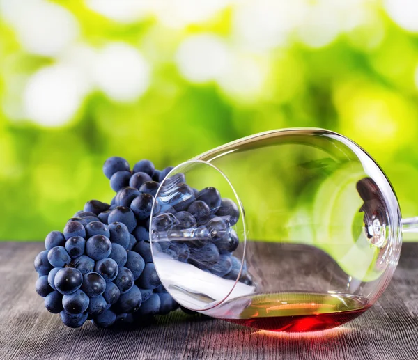 Sklenice na víno s hroznovým vínem na dřevěný stůl — Stock fotografie