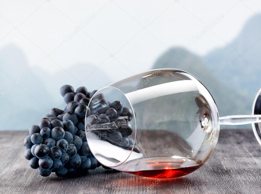 Wine glass with grape on wooden table