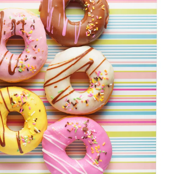 Donuts coloridos en una servilleta a rayas —  Fotos de Stock