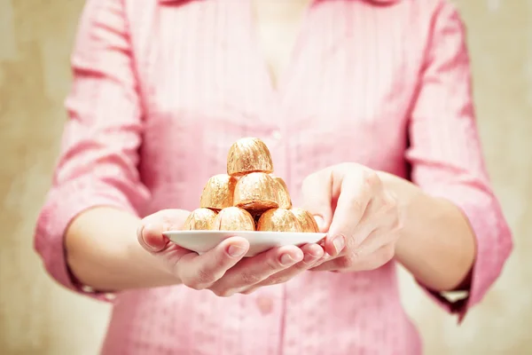 Mujer joven sosteniendo un caramelo de chocolate — Foto de Stock