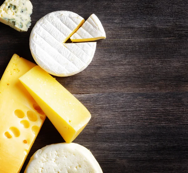 Different types of cheese on a wooden board — Stock Photo, Image