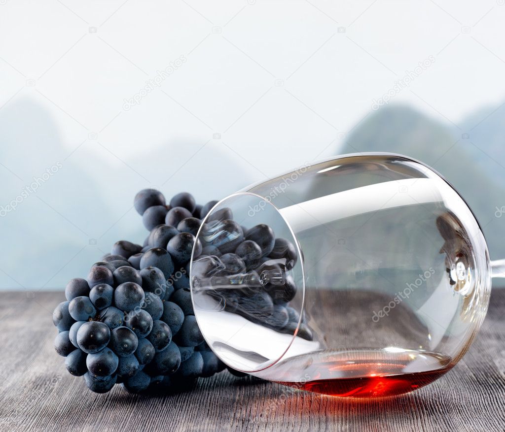 Wine glass with grape on wooden table