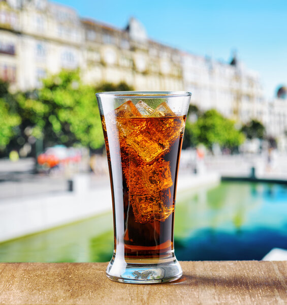 Glass of cola with ice on a table in cafe