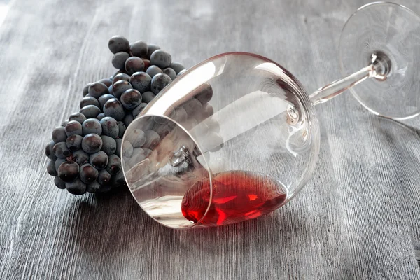 Wine glass with grape on wooden table — Stock Photo, Image