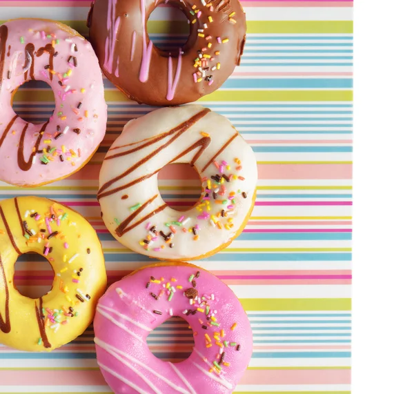 Kleurrijke donuts op een gestreepte servet — Stockfoto