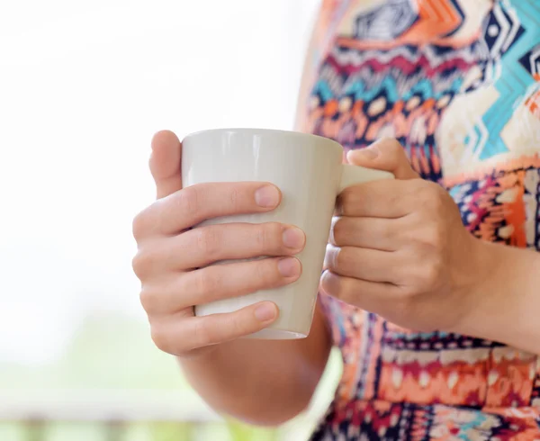 Jovem mulher desfrutando de uma caneca de bebida . — Fotografia de Stock