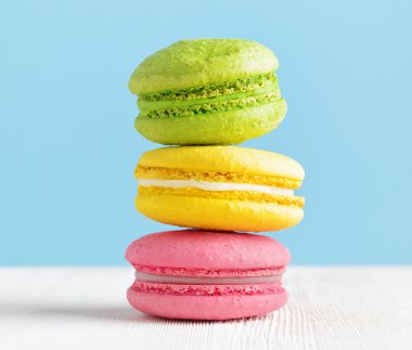 Beyaz ahşap bir masa üzerinde renkli macaron