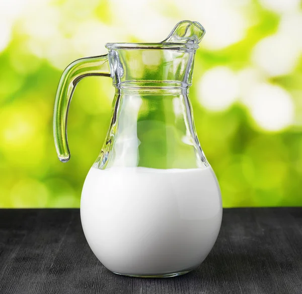 Caraffa di latte biologico su sfondo naturale — Foto Stock