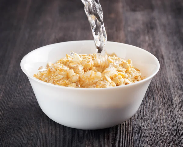 Schüssel Haferflocken auf einem Holztisch — Stockfoto