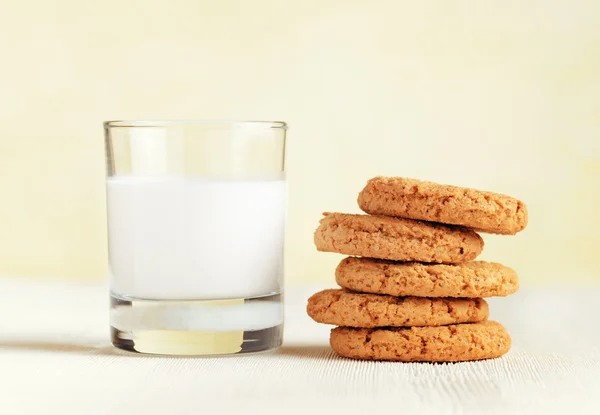 Oatmeal cookies and glass of milk on a wooden table — Stock Photo, Image