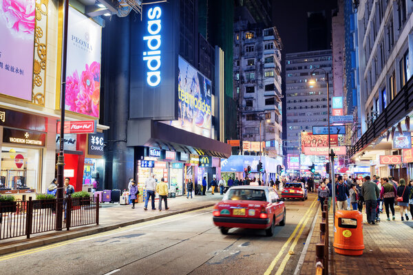 HONG KONG - JANUARY 31, 2015: Taxi and illuminated signs on the street of night city. Hong Kong is popular tourist destination of Asia and leading financial centre of the world
