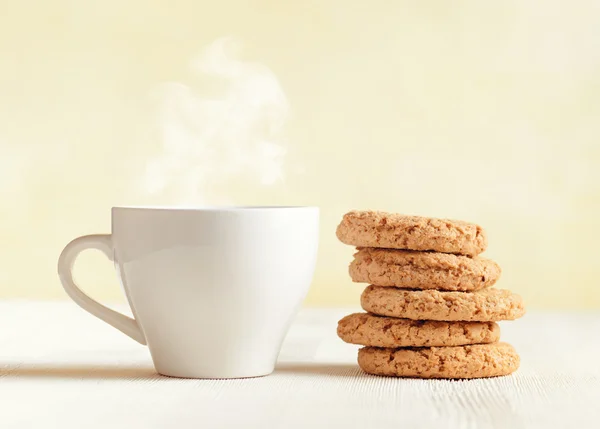 Oatmeal cookies and cup of coffee on wooden table — Stock Photo, Image