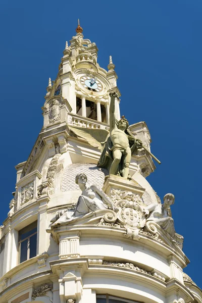 Der Uhrturm und die Skulpturen, die die Fassade des Gebäudes zieren — Stockfoto