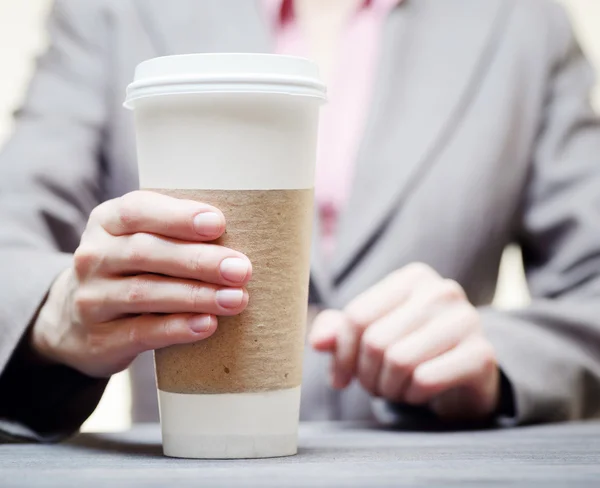 Zakenvrouw met een tuimelaar van koffie. Close-up weergave — Stockfoto