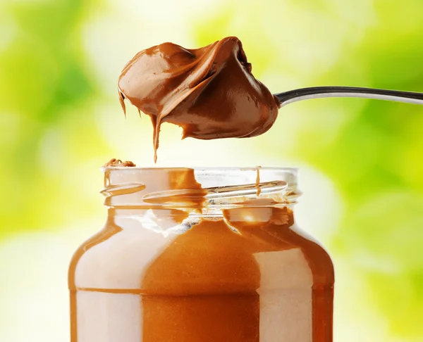 A jar of hazelnut chocolate spread on nature background — Stock Photo, Image